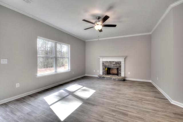 unfurnished living room featuring ceiling fan, a fireplace, wood-type flooring, and ornamental molding