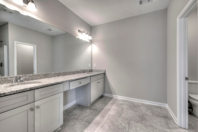 bathroom with vanity, toilet, and tile patterned floors