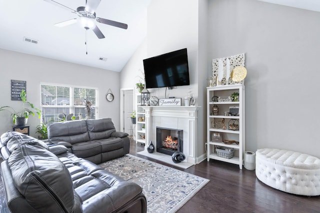 living room with high vaulted ceiling, a tile fireplace, ceiling fan, and dark hardwood / wood-style floors