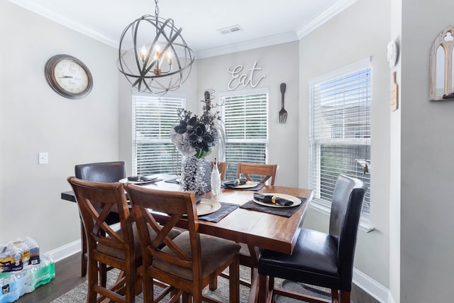 dining area featuring crown molding, a chandelier, and hardwood / wood-style floors