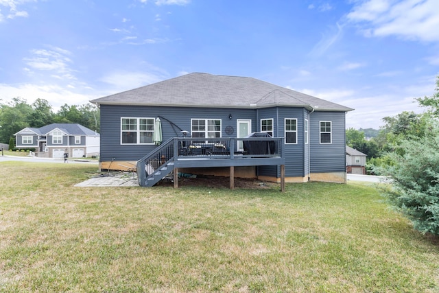 rear view of property featuring a yard and a wooden deck