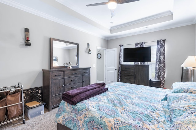 bedroom with ornamental molding, a tray ceiling, ceiling fan, and carpet