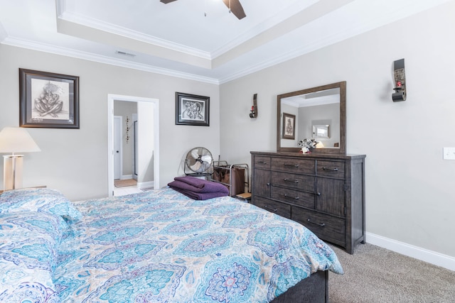 bedroom with ornamental molding, light carpet, a tray ceiling, and ceiling fan