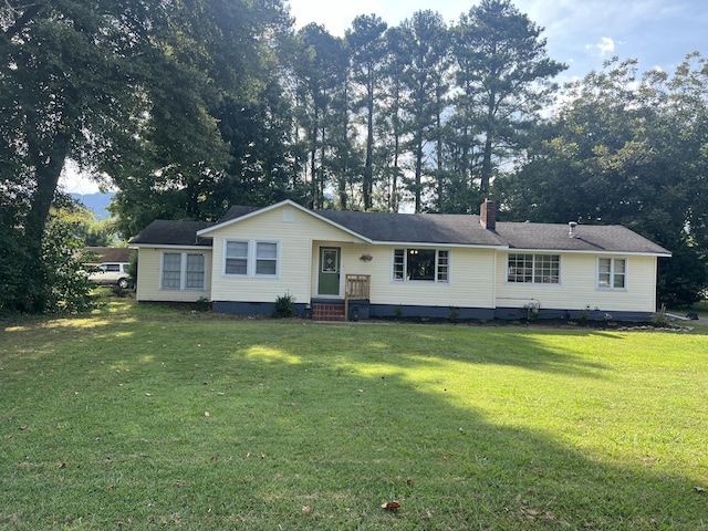view of front facade with a front yard, crawl space, and a chimney