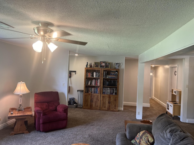 living area featuring a textured ceiling, carpet floors, baseboards, and a ceiling fan