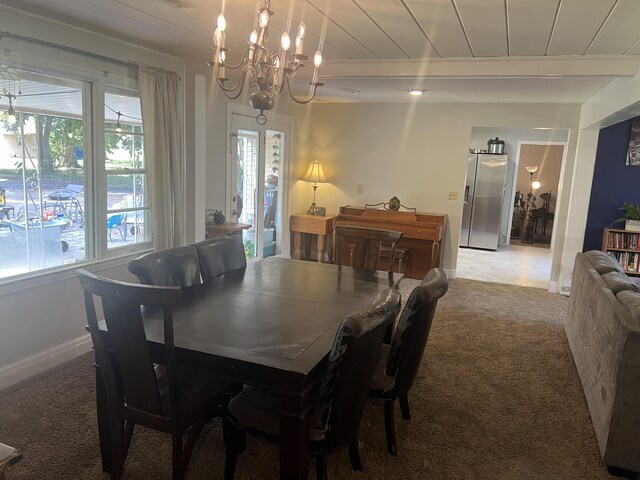 carpeted dining space featuring an inviting chandelier, beamed ceiling, and wooden ceiling