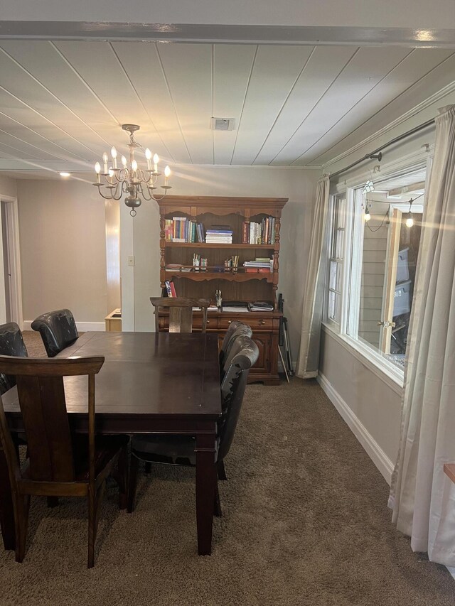 dining space with carpet flooring and a chandelier