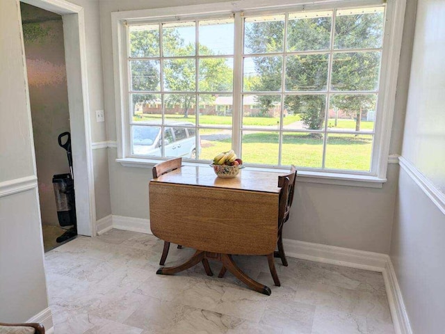 dining room featuring baseboards, marble finish floor, and a healthy amount of sunlight
