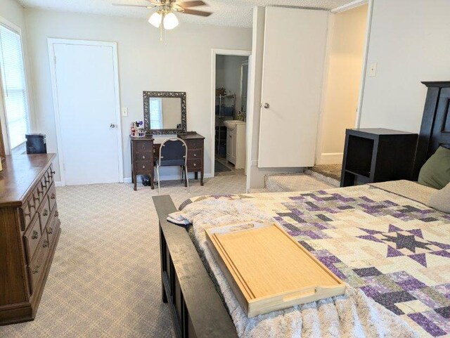 bedroom with a textured ceiling, light colored carpet, ceiling fan, and ensuite bathroom