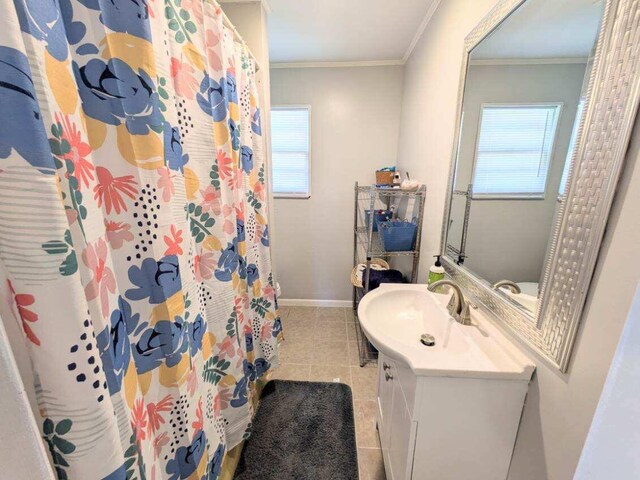 bathroom with ornamental molding, vanity, a wealth of natural light, and tile patterned flooring