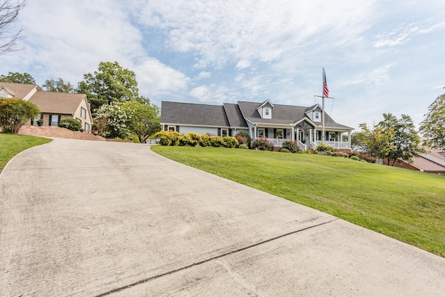 new england style home featuring a porch and a front lawn