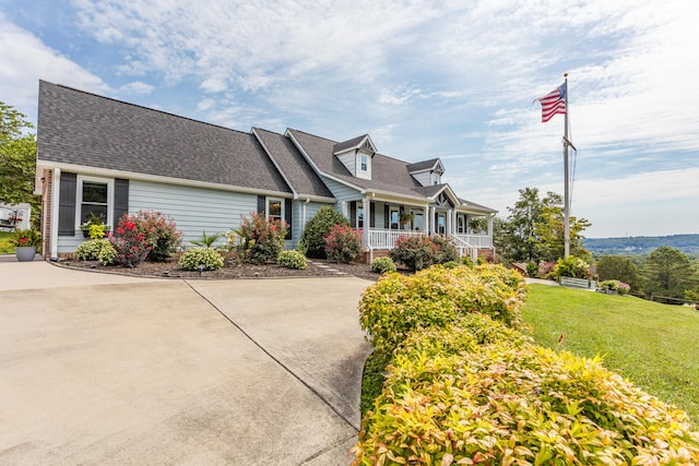 new england style home featuring a porch and a front yard