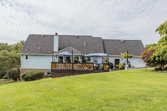 back of property with a yard and a wooden deck