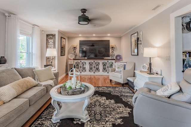 living room featuring crown molding, hardwood / wood-style floors, and ceiling fan