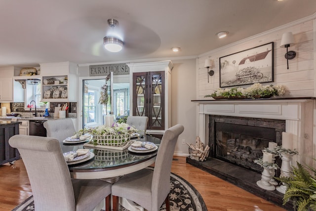 dining area featuring sink, crown molding, and light hardwood / wood-style flooring