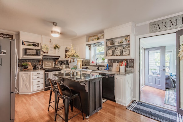 kitchen with black appliances, white cabinetry, plenty of natural light, and light stone counters