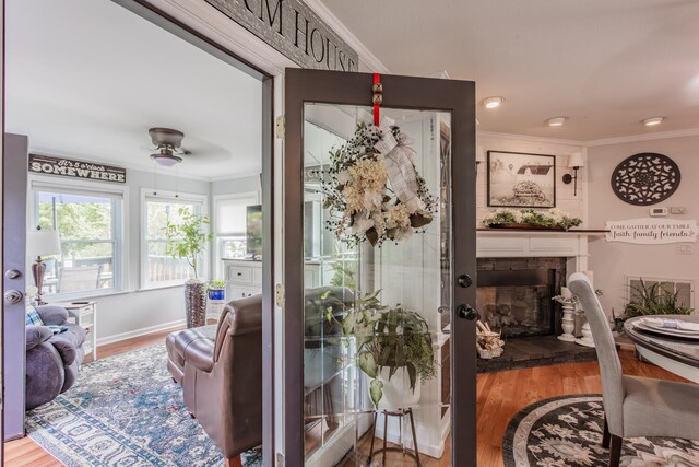 living room featuring hardwood / wood-style floors, ceiling fan, and ornamental molding