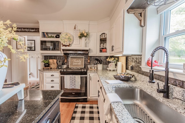 kitchen with sink, white cabinetry, light wood-type flooring, stone counters, and stainless steel range with electric cooktop