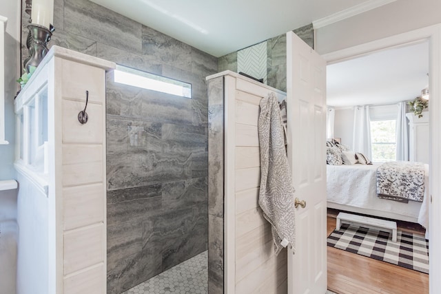 bathroom with tiled shower, hardwood / wood-style floors, and ornamental molding