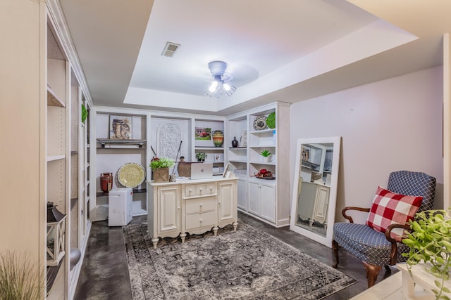 office space featuring a tray ceiling and ceiling fan