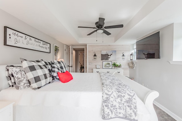 bedroom with ceiling fan and a tray ceiling