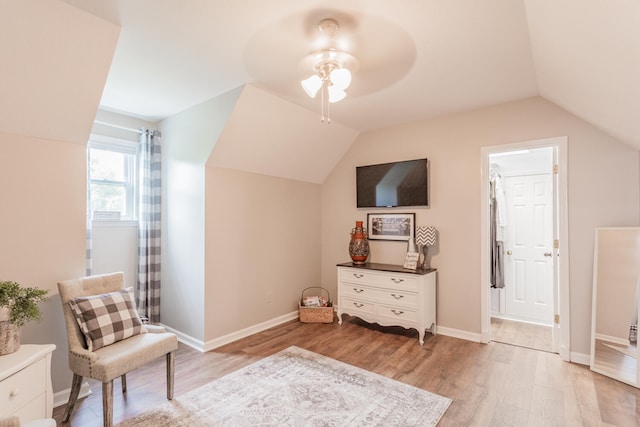 sitting room featuring light wood-type flooring, vaulted ceiling, and ceiling fan