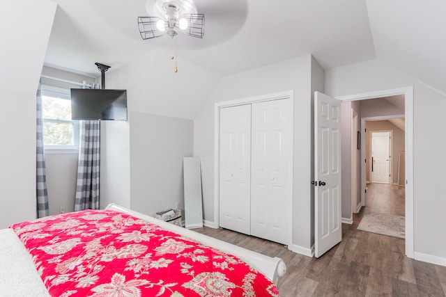 bedroom with vaulted ceiling, wood-type flooring, ceiling fan, and a closet