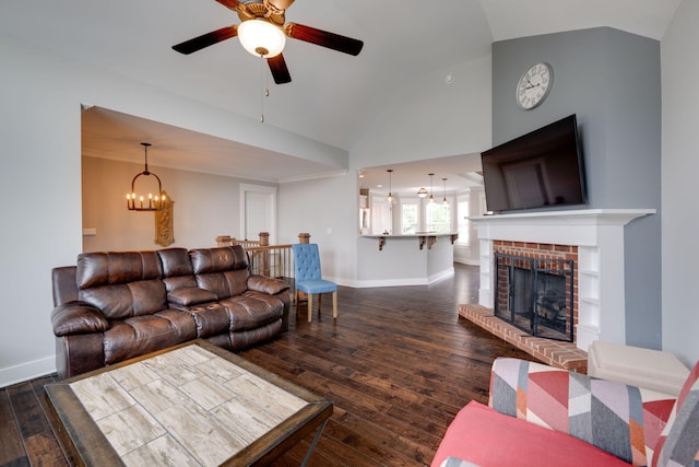 living room featuring a fireplace, dark wood-type flooring, ceiling fan with notable chandelier, and vaulted ceiling