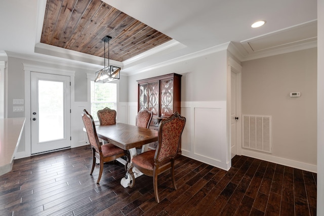 dining space with wood ceiling, a raised ceiling, dark hardwood / wood-style flooring, and ornamental molding