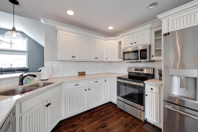 kitchen featuring backsplash, appliances with stainless steel finishes, sink, dark wood-type flooring, and pendant lighting