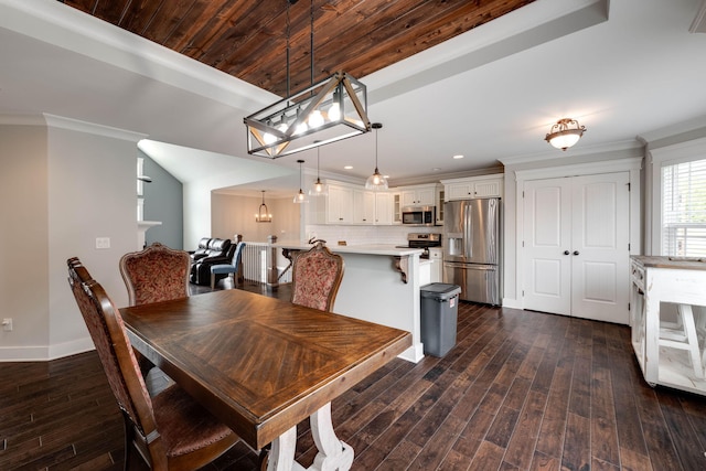 dining space featuring dark wood-type flooring and crown molding