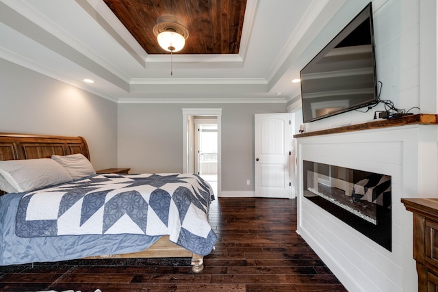 bedroom featuring ornamental molding, dark hardwood / wood-style flooring, a tray ceiling, and ceiling fan