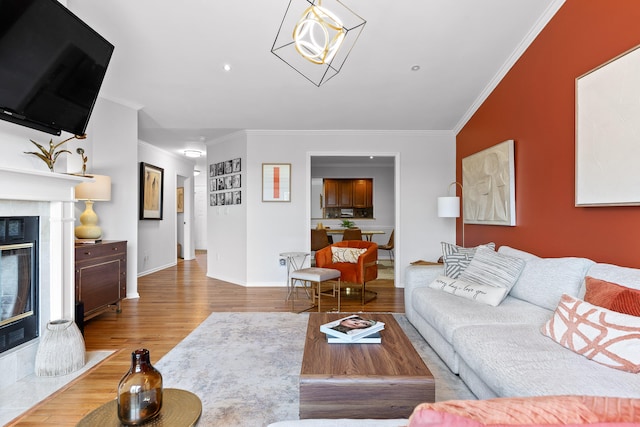 living room featuring a premium fireplace, ornamental molding, and hardwood / wood-style floors