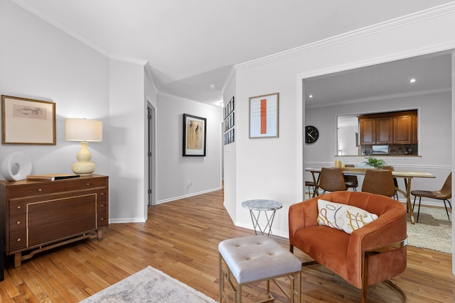 living area with crown molding and light hardwood / wood-style floors