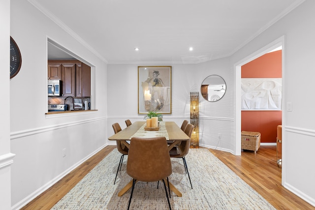 dining room featuring ornamental molding and light wood-type flooring