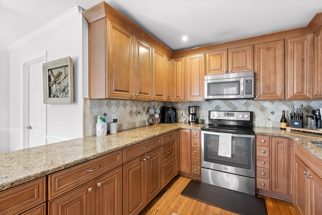 kitchen with crown molding, light stone countertops, stainless steel appliances, light hardwood / wood-style floors, and decorative backsplash