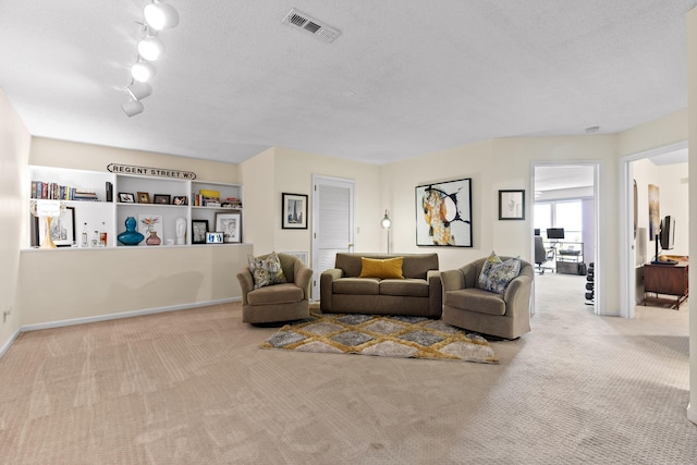 carpeted living room with rail lighting and a textured ceiling