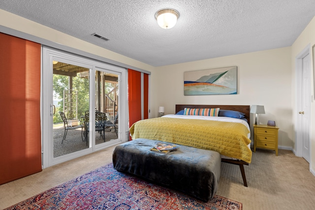 carpeted bedroom with a textured ceiling and access to exterior