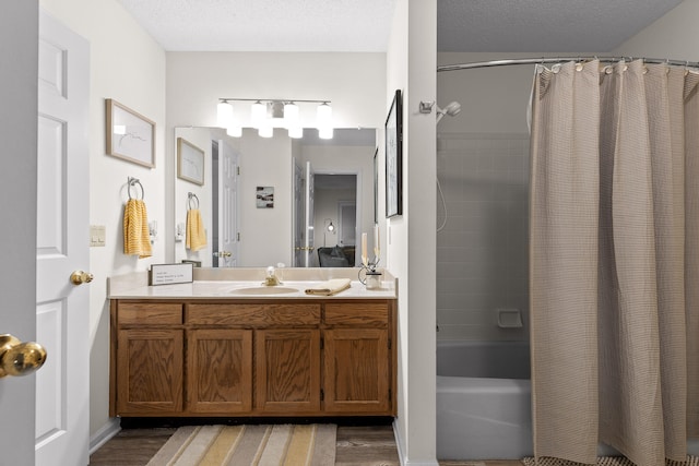 bathroom featuring a textured ceiling, vanity, wood-type flooring, and shower / bath combo