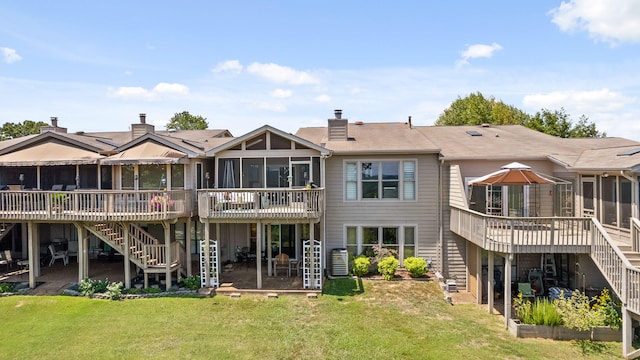 rear view of house with a yard, a sunroom, and a deck