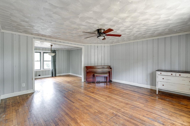 unfurnished living room with crown molding, a textured ceiling, hardwood / wood-style flooring, and ceiling fan