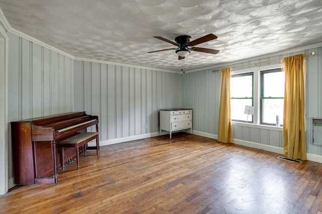 misc room with ornamental molding, wood-type flooring, and ceiling fan