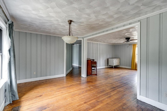 unfurnished living room with wood-type flooring and ceiling fan