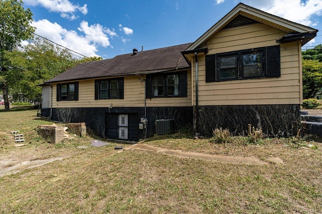 view of front of property with central AC unit and a front yard