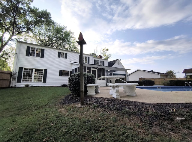 back of house with a patio, a sunroom, and a lawn