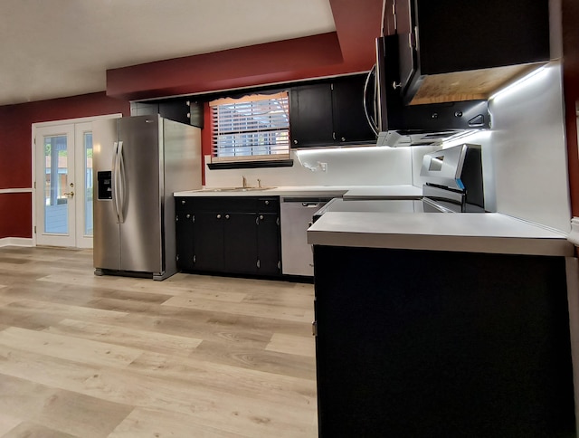 kitchen with stainless steel appliances, sink, light wood-type flooring, and french doors