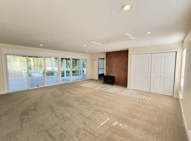 unfurnished living room with light colored carpet and a textured ceiling