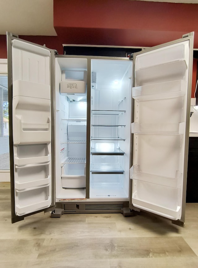 room details featuring hardwood / wood-style floors and refrigerator