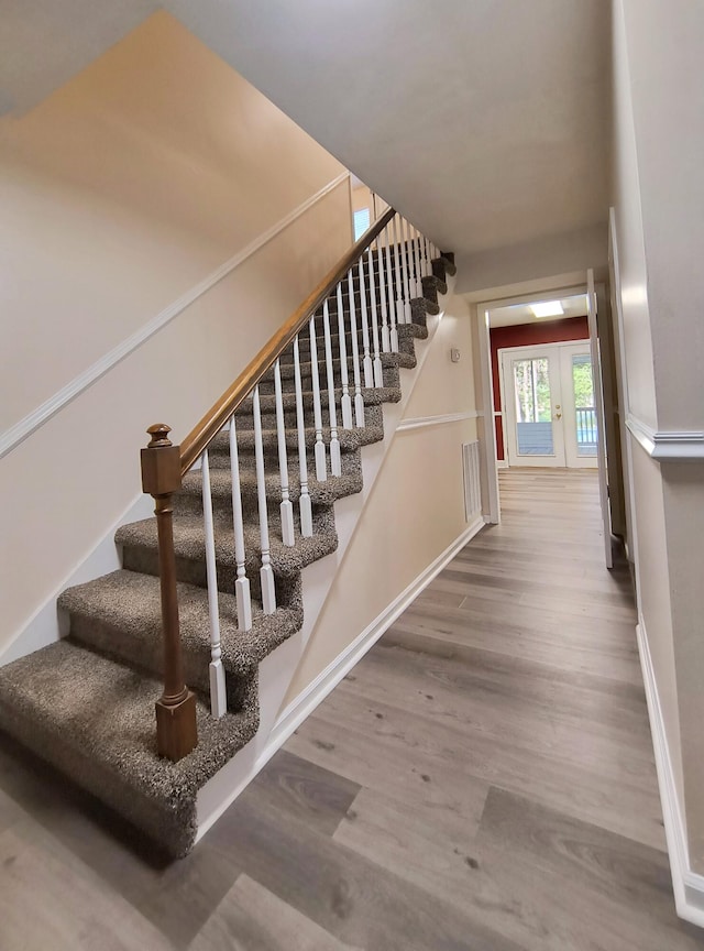 staircase with hardwood / wood-style floors