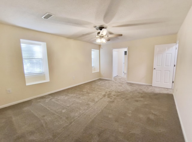 carpeted spare room with ceiling fan